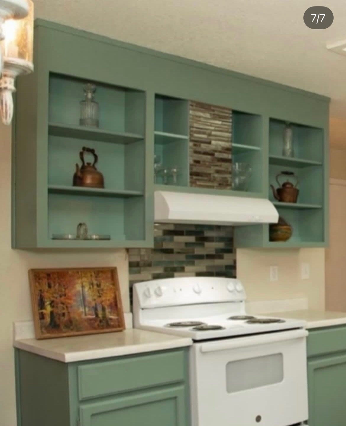 Finished sage green kitchen with open shelving and glass tile backsplash